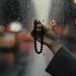 Portable Altar by Yuano: A handcrafted obsidian necklace held against the blurred lights of a rainy city.