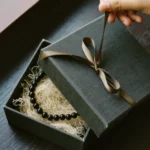 Sacred Token by Yuano: A handcrafted obsidian necklace in a luxury charcoal gift box with a silk ribbon.