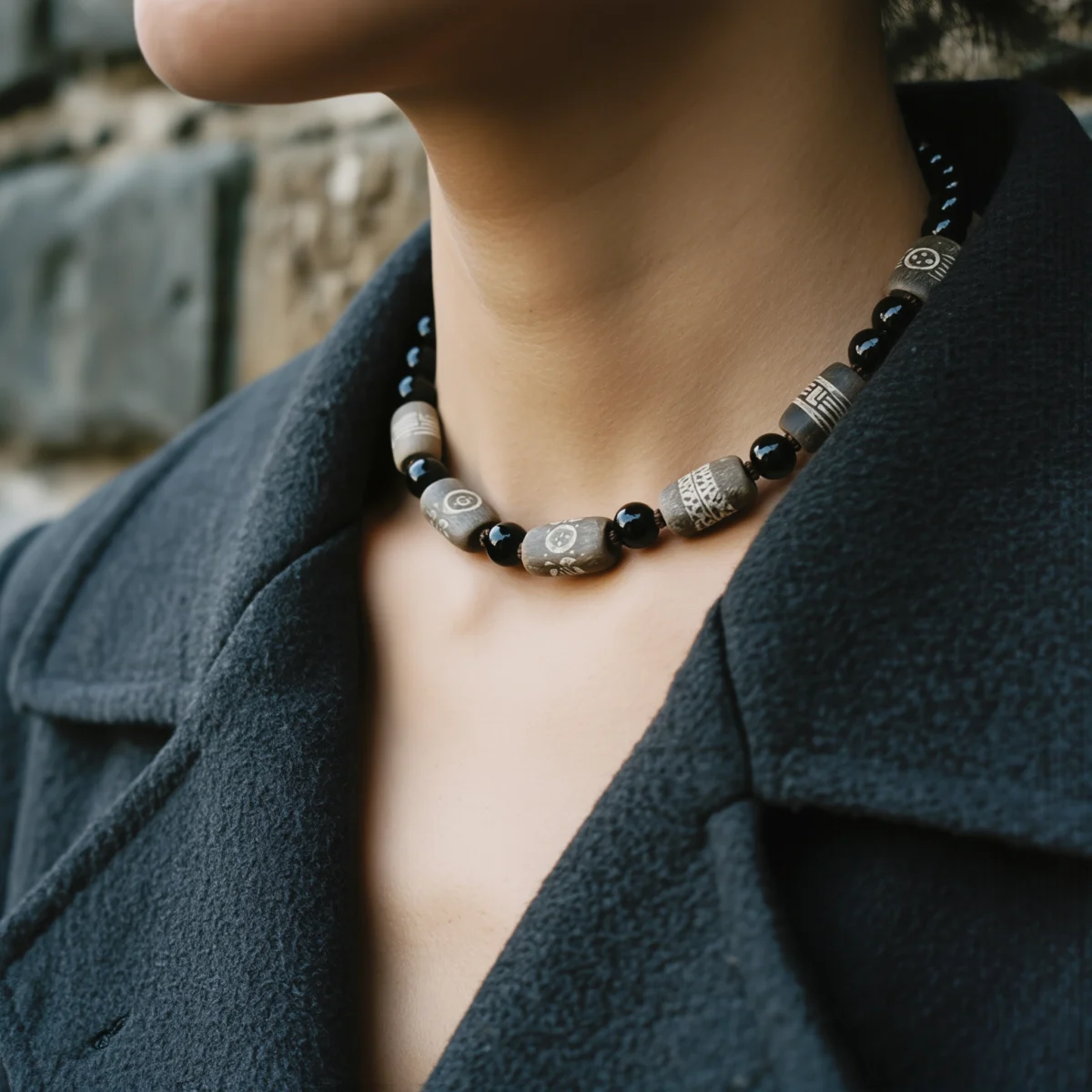 Covenant No. 01 — Lifestyle Observational Poise Covenant No. 01: The Void necklace worn by a model in a structured grey wool coat.