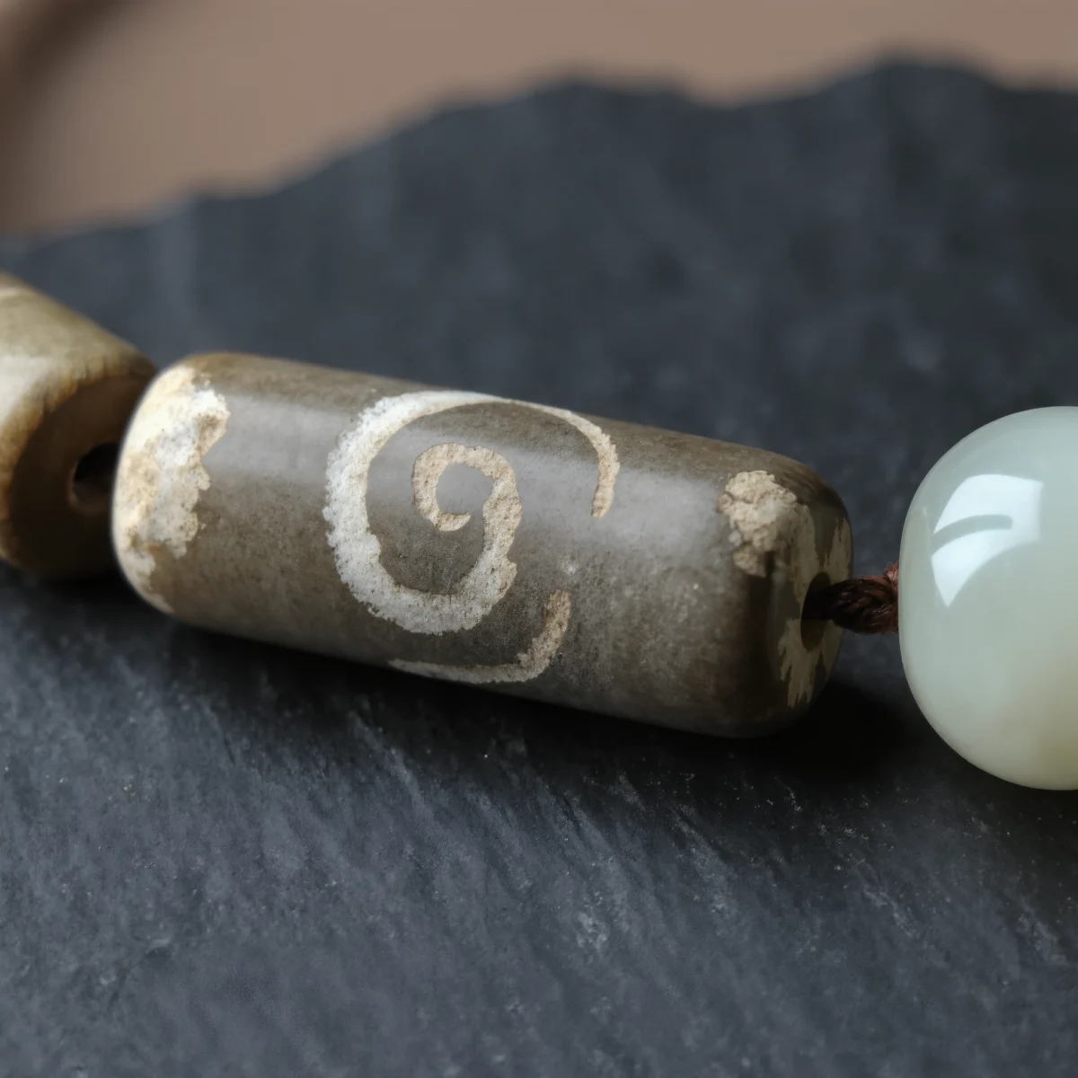 Covenant No. 04 macro detail revealing the weathered spiral etching of Tibet Dzi and the waxy luster of Xinjiang Nephrite Jade.