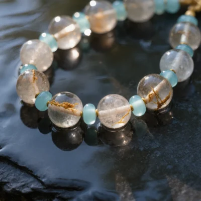 Fluidity No. 09 — Crystal Stream Aqueous Perspective Fluidity No. 09: Crystal Stream hand-knotted necklace featuring Donghai Rutilated Quartz reflected in water.
