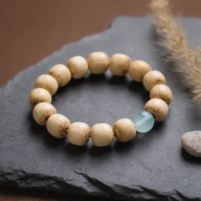 Fluidity No. 10 — Pure Drift Main Perspective Fluidity No. 10: Pure Drift hand-knotted bracelet featuring Hainan Bodhi Root and Xinjiang Aquamarine on slate.