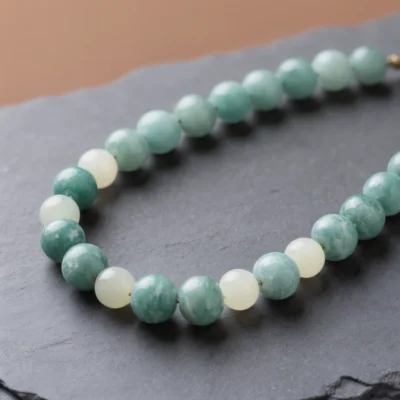Fluidity No. 04 — Aqua Stillness Main Perspective Fluidity No. 04: Aqua Stillness hand-knotted necklace featuring Fujian Amazonite and Xinjiang Nephrite Jade on dark slate.