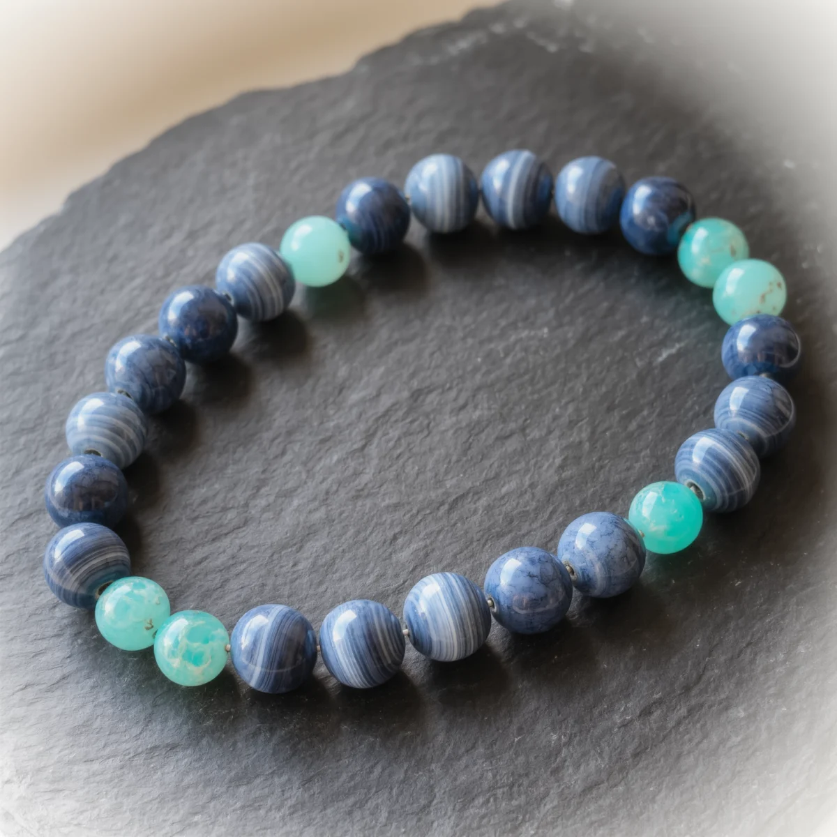 Fluidity No. 06 — Mist & Dew Main Perspective Fluidity No. 06: Mist & Dew hand-knotted necklace featuring Blue Silk Agate and Amazonite on dark slate.