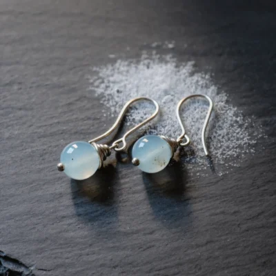 Fluidity No. 07 — Glacial Echo Main Perspective Fluidity No. 07: Glacial Echo hand-knotted earrings featuring Xinjiang Aquamarine and Silver on snow-dusted slate.