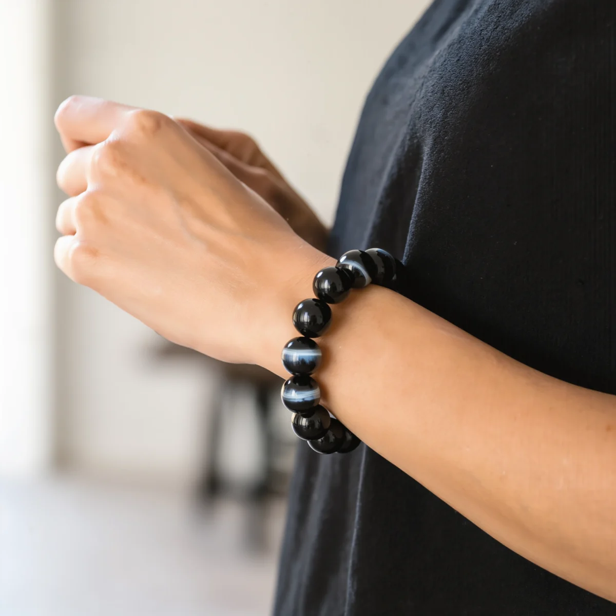 Fortress No. 05 — Lifestyle Observational Poise Fortress No. 05: Dark Armor bracelet worn on a wrist against a minimalist black garment.
