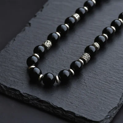 Fortress No. 07 — Night Sentinel Primary Narrative Fortress No. 07: Night Sentinel hand-knotted necklace featuring Tibet Obsidian and Mantra-engraved silver.