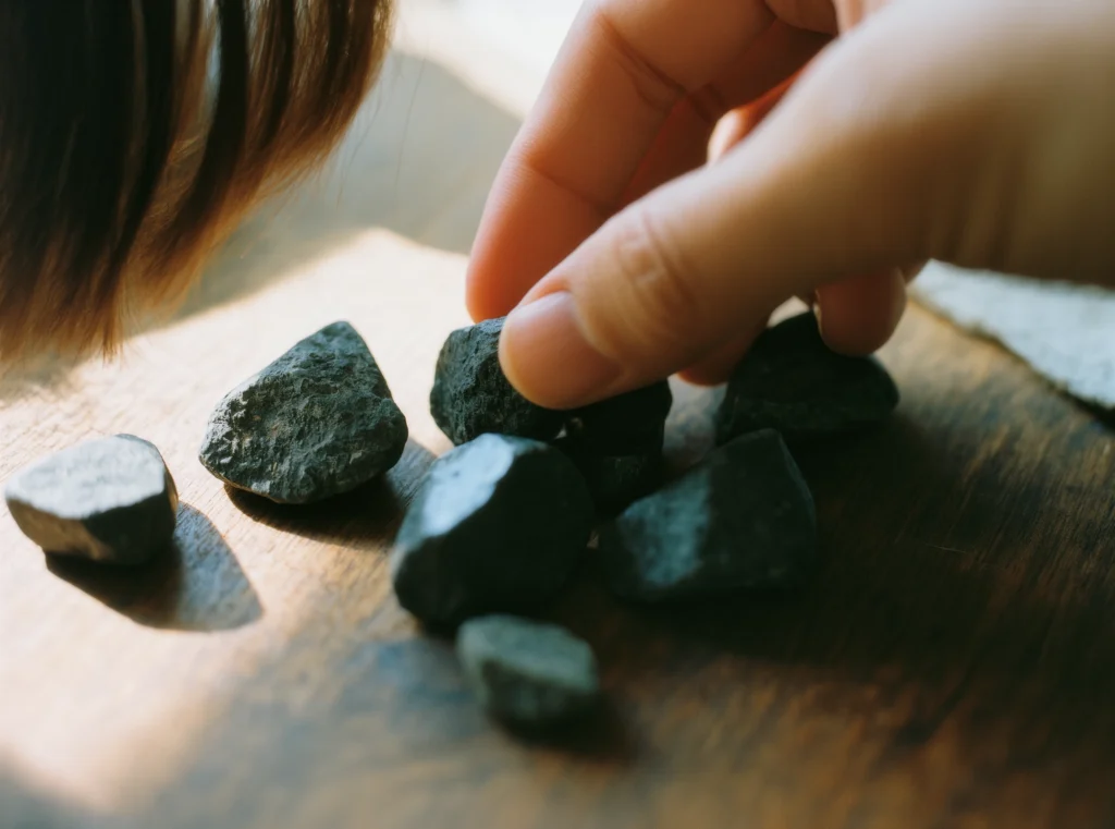 About Us 13 Handcrafted Jewelry by Yuano: Hands identifying raw jasper and obsidian elements.