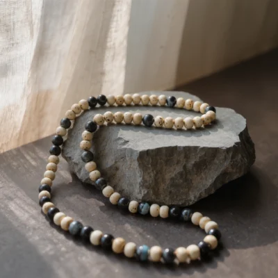 Origin No. 05 — Steady Breath Main Perspective Origin No. 05: Steady Breath hand-knotted necklace featuring Hainan Bodhi Root and Black Tiger Eye beads on a bone-white background.