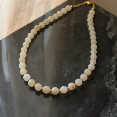Origin No. 09 — Silent Root Main Perspective Origin No. 09: Silent Root hand-knotted necklace featuring Xinjiang Nephrite Jade and gold beads on a dark marble surface.