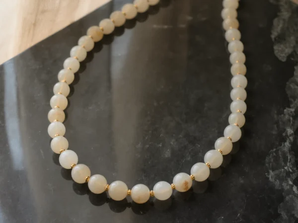 Origin No. 09 — Silent Root Main Perspective Origin No. 09: Silent Root hand-knotted necklace featuring Xinjiang Nephrite Jade and gold beads on a dark marble surface.