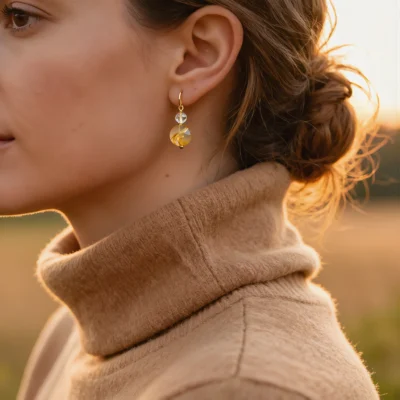 Radiance No. 03 — Lifestyle Observational Glow Radiance No. 03: Golden Ray earrings worn by a model against the backdrop of a soft sunset glow.