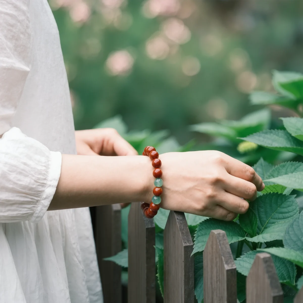 Radiance No. 05 — Lifestyle Flourishing Perspective Radiance No. 05: Vitality Bloom bracelet worn on a wrist against a backdrop of verdant garden foliage.