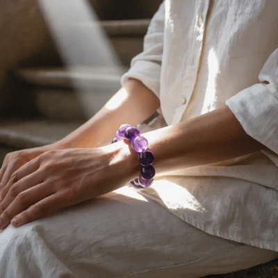 Serenity No. 02 — Lifestyle Observational Clarity Serenity No. 02: Lavender Peace bracelet worn by a model in a meditative pose with strong natural highlights.